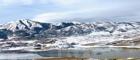 A mountainous landscape with a lake and a small settlement.