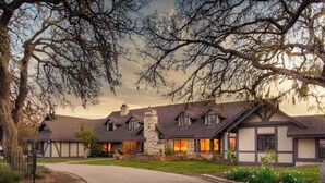 A large, multi-story house with a stone chimney, multiple windows, and a well-maintained lawn. - Cathedral by Avantstay Charming Secluded Estate w/ Sauna, Pool Table & Views of the Rolling Hills (Templeton)