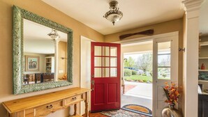 A wooden bench, a red door, and a mirror with a decorative frame. - 4.5 Acre Secluded Ranch w/ Panoramic Views Fire Pit Olive Ranch by Avantstay (Paso Robles)