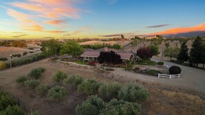 A large house with a fenced yard, surrounded by trees and open fields. - 4.5 Acre Secluded Ranch w/ Panoramic Views Fire Pit Olive Ranch by Avantstay (Paso Robles)