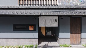 A building entrance with a tiled pathway, a wooden door, and a sign with the name "ORI ROKKAKU". - ORI Rokkaku (Kyoto)