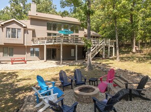 A two-story house with a deck, outdoor seating area, and a fire pit. - The Aspen Cottage by Innsbrook Vacations! (Innsbrook)