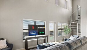 Relax in this stylish living room with a flat-screen TV, comfortable sofa, and potted plant.