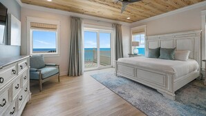 A bedroom with a large bed, a dresser, a chair, and a ceiling fan. - A Gulf Dream - Gulf Front with Private Pool and Carriage House (Santa Rosa Beach)