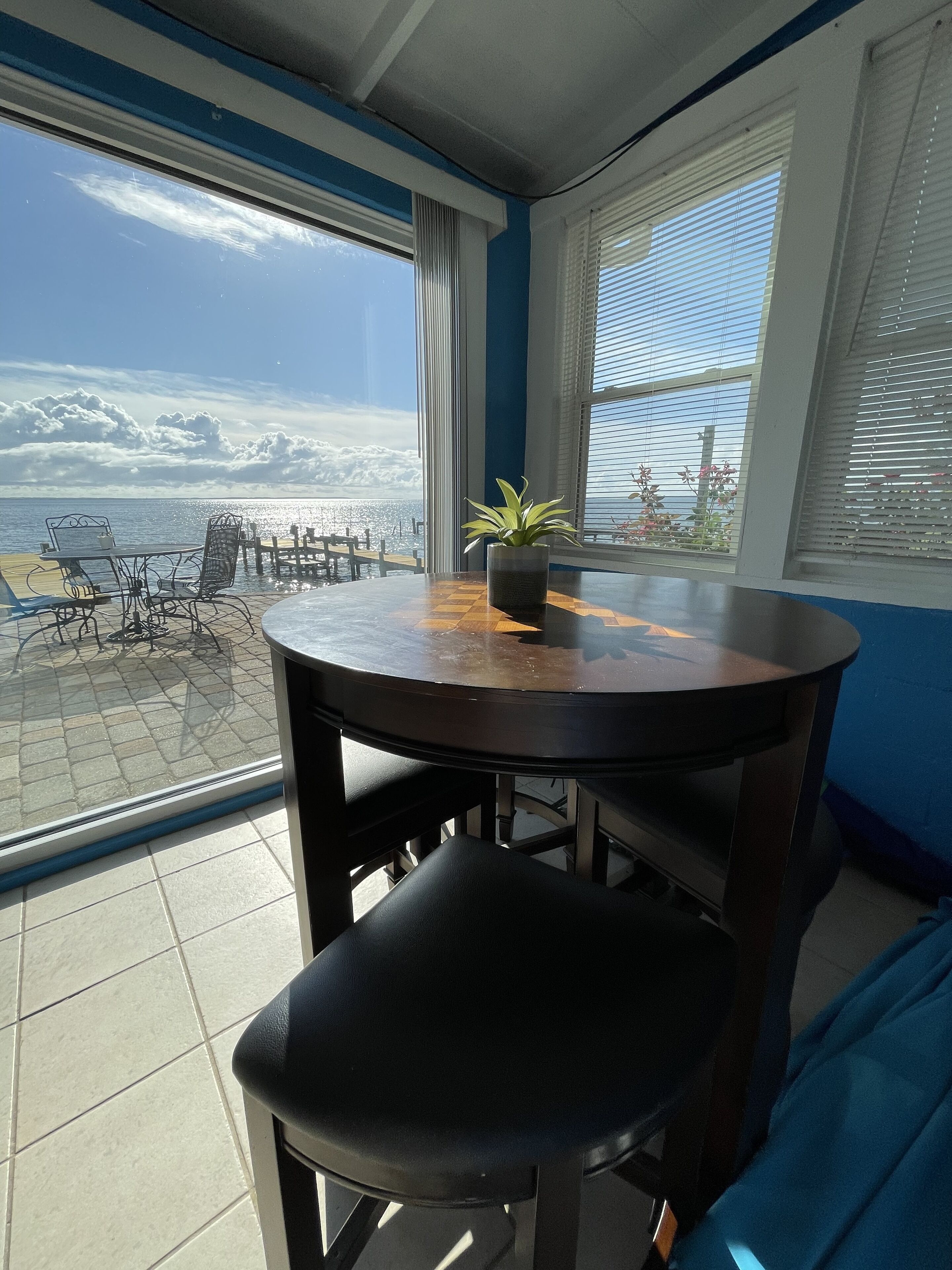 En matplats med utsikt över havet, en krukväxt och en blå soffa.