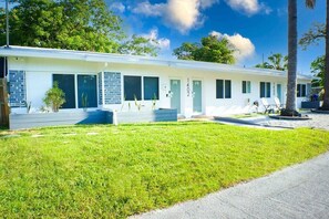 Simple, single-story motel with a well-maintained lawn and peaceful surroundings.
