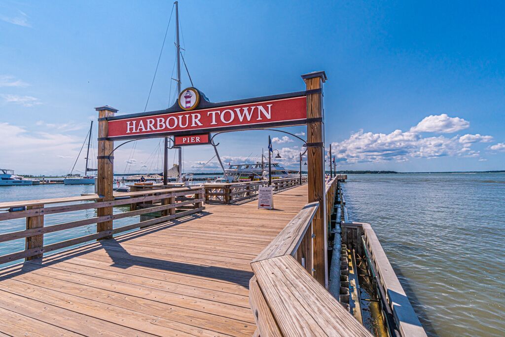 A wooden pier leading to Harbour Town Pier with a sign indicating the location.