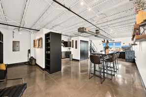 Un vaste espace de vie à aire ouverte comprenant une cuisine, un coin repas et un espace salon.