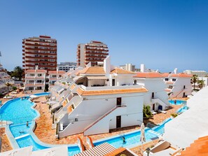 A resort with multiple swimming pools, a central staircase, and a view of surrounding buildings. - Las Floritas 23 Terrace and Swimming Pool (Playa de las Américas)