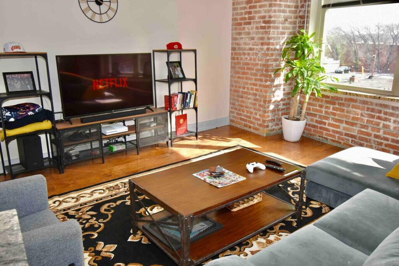 A living room with a flat-screen TV, a bookshelf, a coffee table, and a couch.