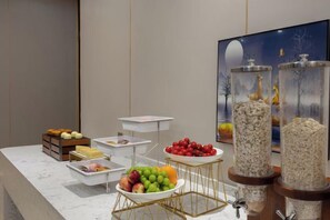 A buffet setup with various food items and decorative elements. - Vienna International Hotel (Du'an Station) (Du'an)