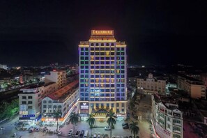 A multi-story hotel with a prominent sign at the top, a central courtyard, and surrounding buildings. - Vienna International Hotel (Du'an Station) (Du'an)