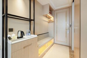 A modern kitchen with a built-in bench, a kettle, and a coffee maker. - Vienna International Hotel (Du'an Station) (Du'an)