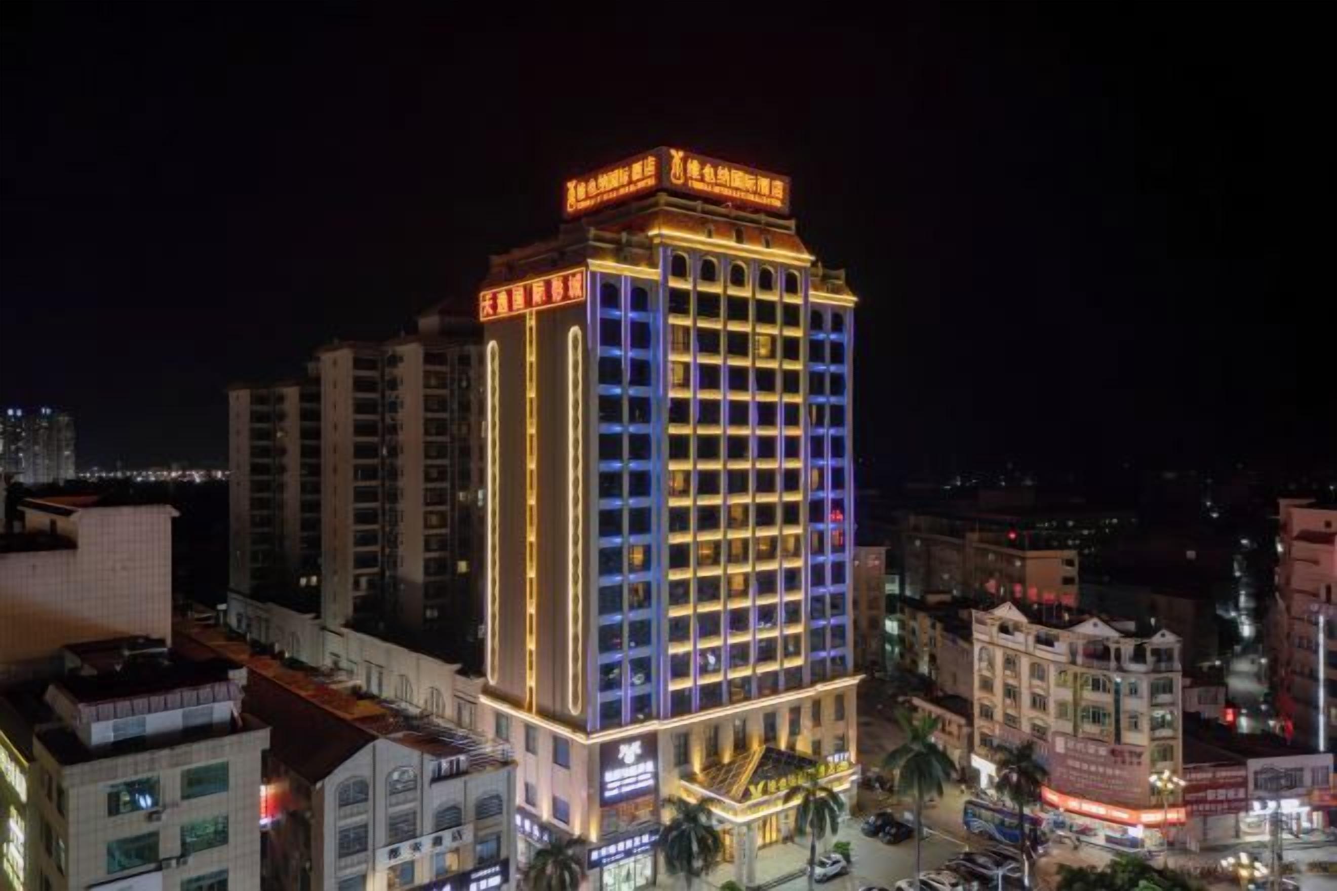 A multi-story hotel with illuminated signage, a prominent entrance, and a surrounding urban environment.