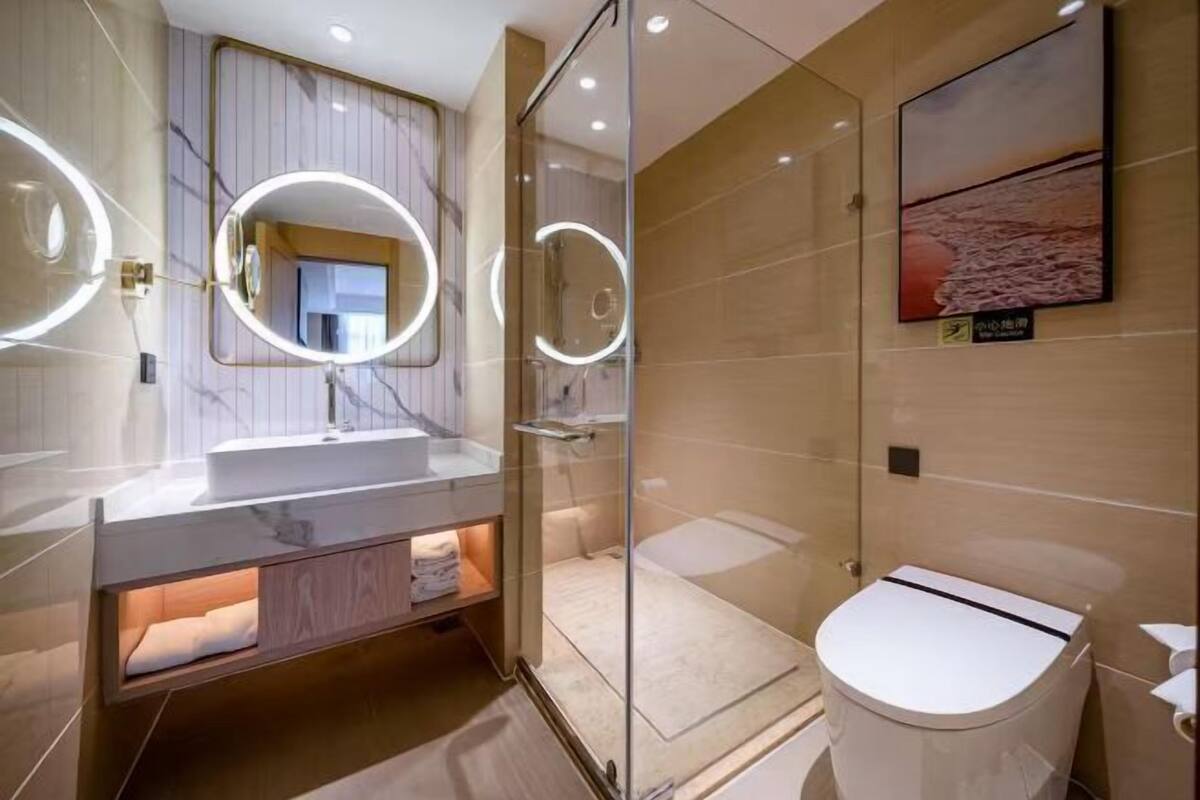 Un bagno moderno con doccia vetrata, un mobile lavabo con specchio e il water.