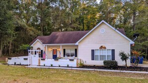 A single-story house with a front porch, a garage, and a satellite dish. - Auburn Tiger Alumni Retreat on 20 acres (Salem)