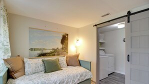 A bedroom with a bed, a painting, a laundry area, and a sliding door. - 'The River Cottage' Isle of Wight Retreat w/ Dock (Midway)