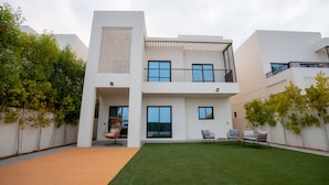 A modern two-story building with a flat roof, large windows, and a balcony. - Eagle Hills (Al-Fujairah)