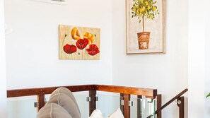 Ein Zimmer mit einer hölzernen Bank, einem Glastisch und zwei Bildern an der Wand.