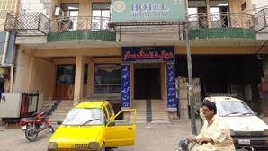 A hotel named "Shining Star" with a signboard, a reception area, and a taxi parked in front. - Hotel Shining Star (Mekhtar)