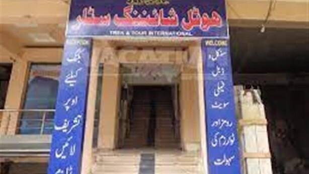 A building entrance with a sign in a foreign language, possibly indicating a hotel or similar establishment. - Hotel Shining Star (Mekhtar)
