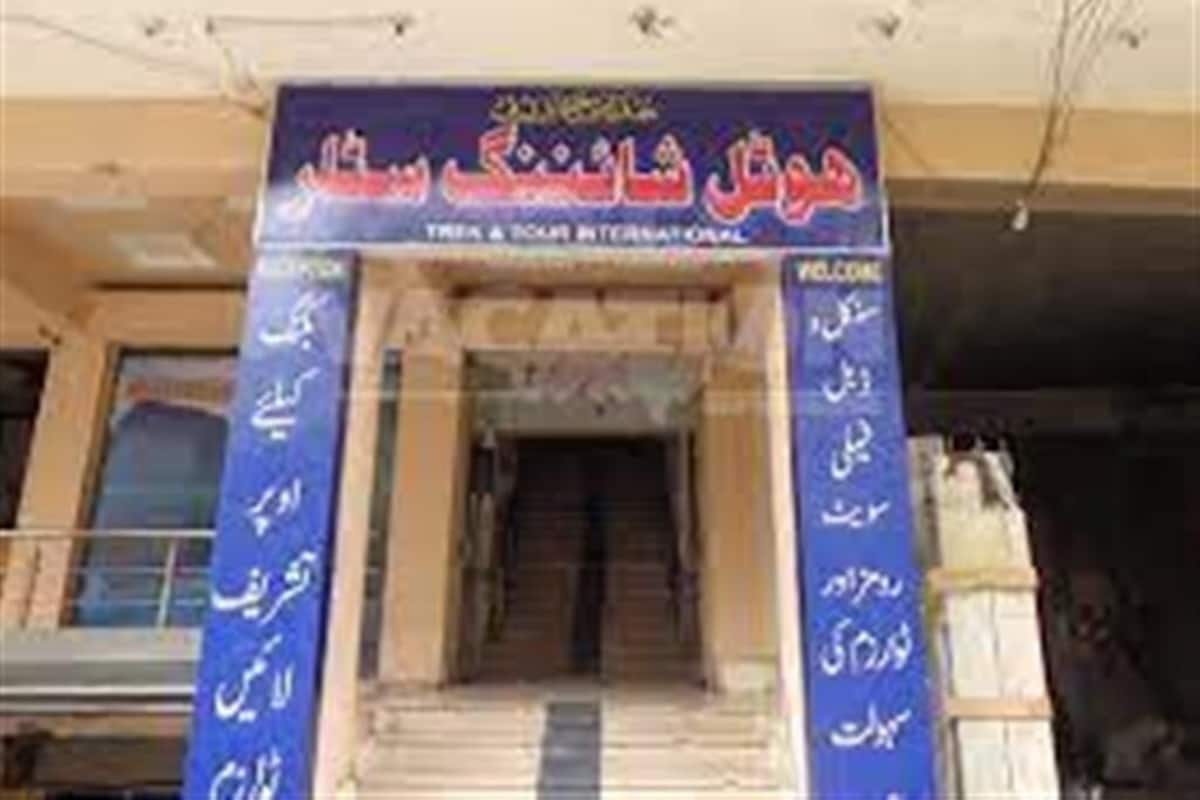 A building entrance with a sign in a foreign language, possibly indicating a hotel or similar establishment.