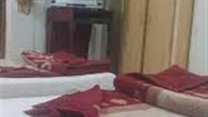 A room with two beds, a television, and a wardrobe. - Hotel Shining Star (Mekhtar)