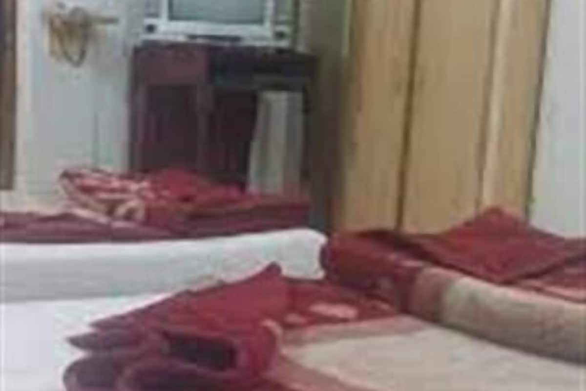 A room with two beds, a television, and a wardrobe.