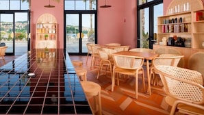 Un restaurante con suelo de baldosas, mobiliario de mimbre y estanterías con frascos.