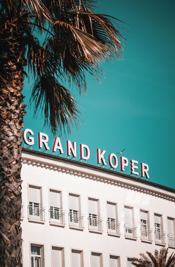 A building with a sign reading "GRAND KOPER" and multiple balconies. - Grand Koper (Koper)