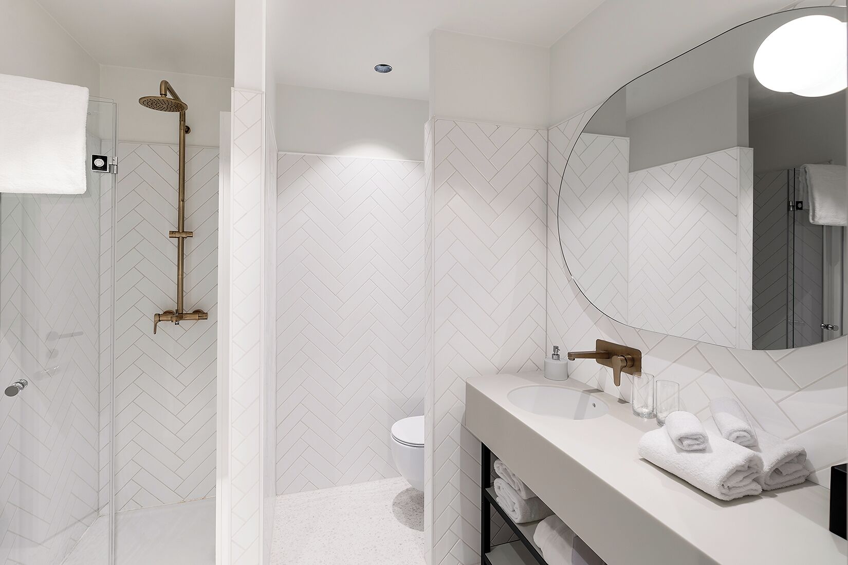 A modern bathroom with a shower, toilet, and vanity.
