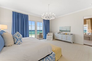 Une chambre d’hôtel avec un grand lit, un bureau équipé d’un ordinateur, une chaise et une vue sur l’océan.