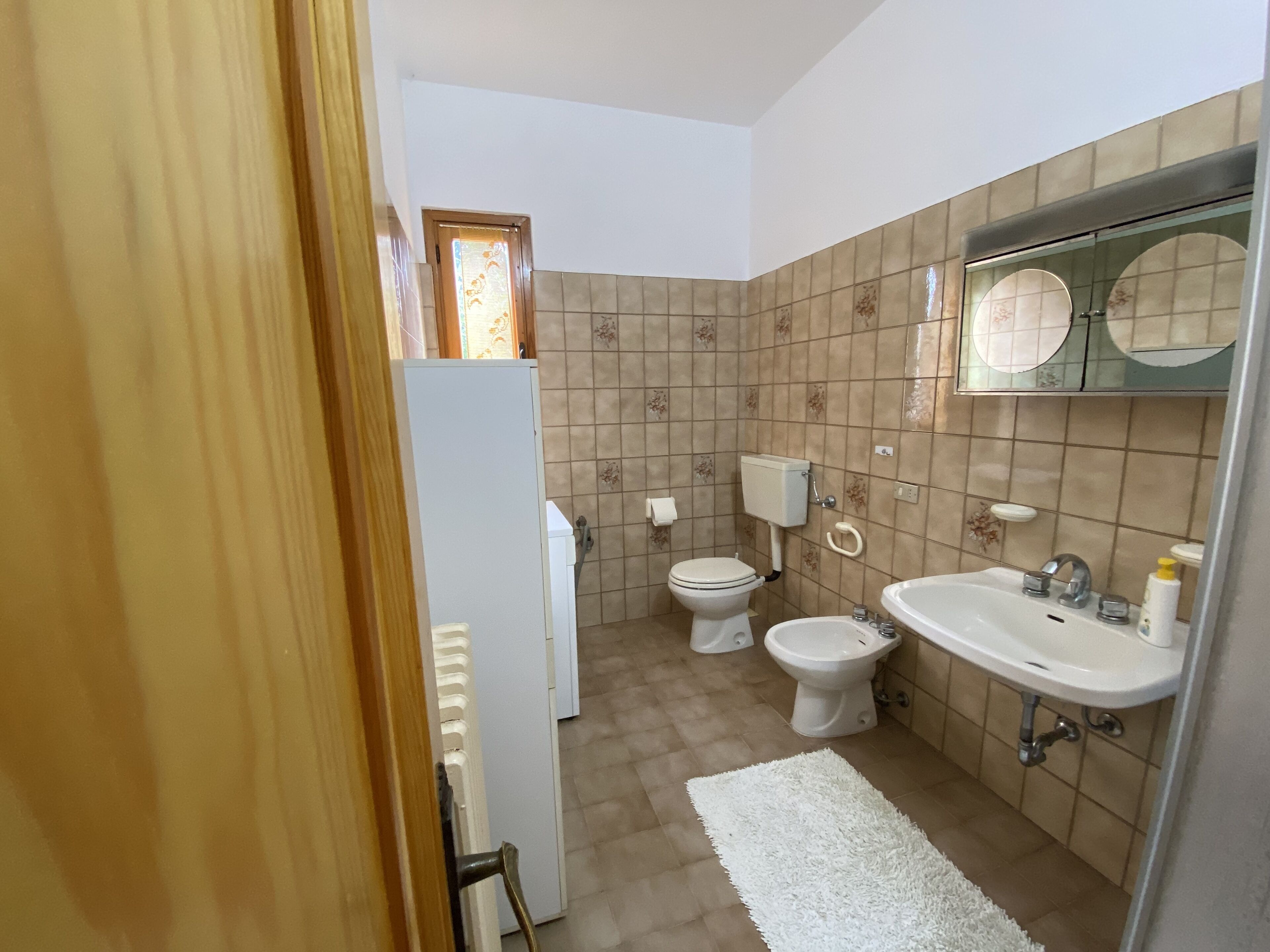 Un bany petit amb vàter, bidet i rentapel.