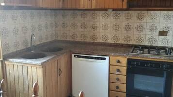 Kühlschrank, Herdplatte, Kochgeschirr/Geschirr/Besteck, Esstisch