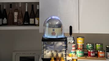 A bar area with a neon sign, shelves of liquor bottles, a coffee machine, and canned beverages.