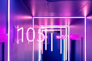 Un letrero de neón con el número 105 en un entorno moderno e iluminado.