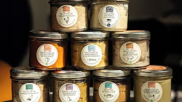 Un montón de frascos con etiquetas que indican que contienen diferentes tipos de pescado en conserva y crema.