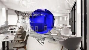 A modern interior with a central blue-lit area, white seating, and a mix of tables and chairs. - Graphik Montparnasse (Paris)