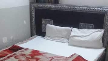 A bed with a patterned bedspread and a headboard with a decorative frame.