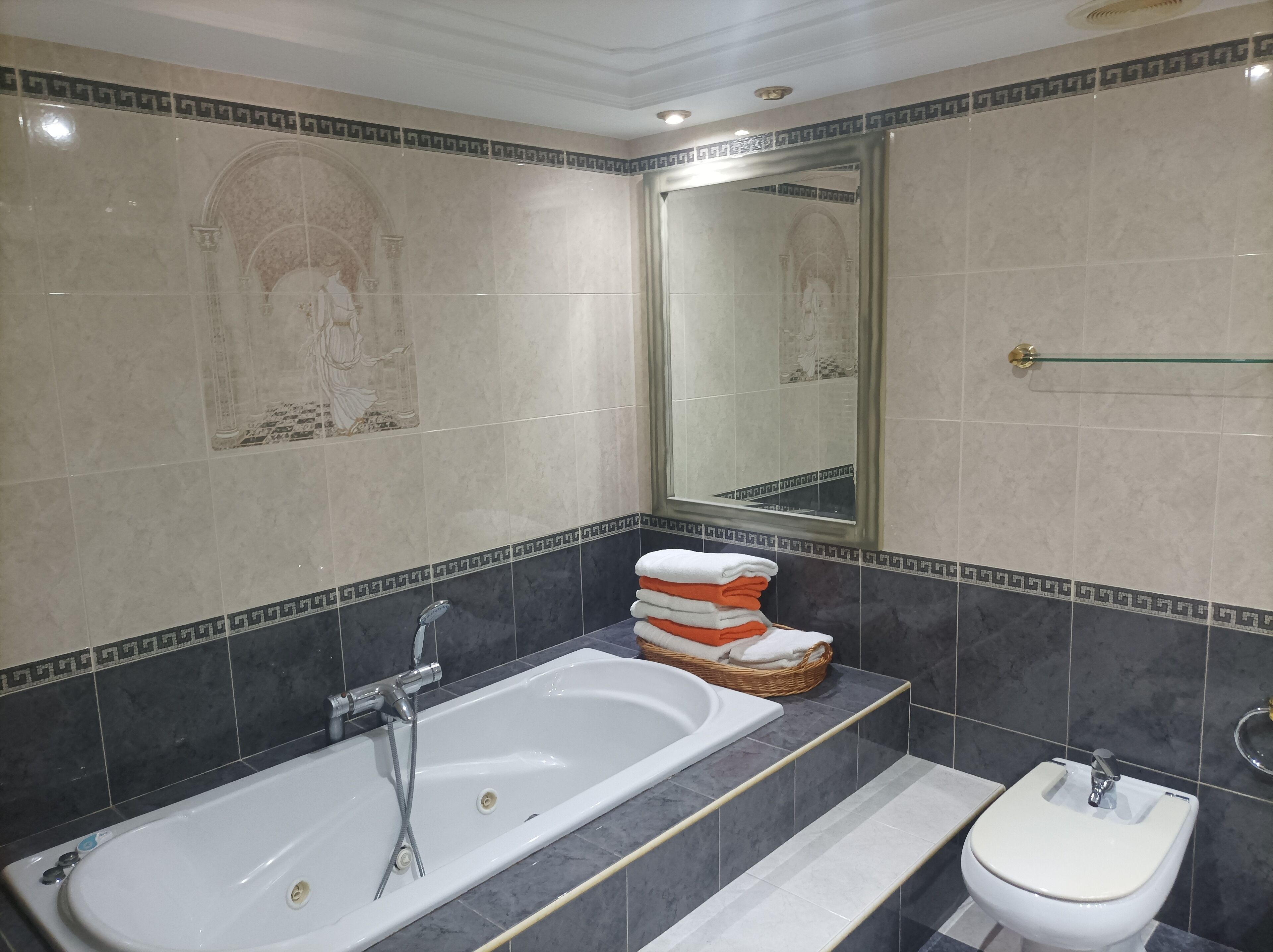 Een badkamer met een bad, een wastafel en een spiegel.