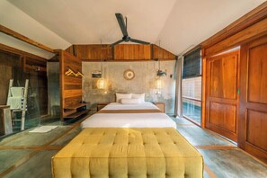 A bedroom with a bed, a ceiling fan, and wooden walls. - Turtle Villas Canggu (Tibubeneng)