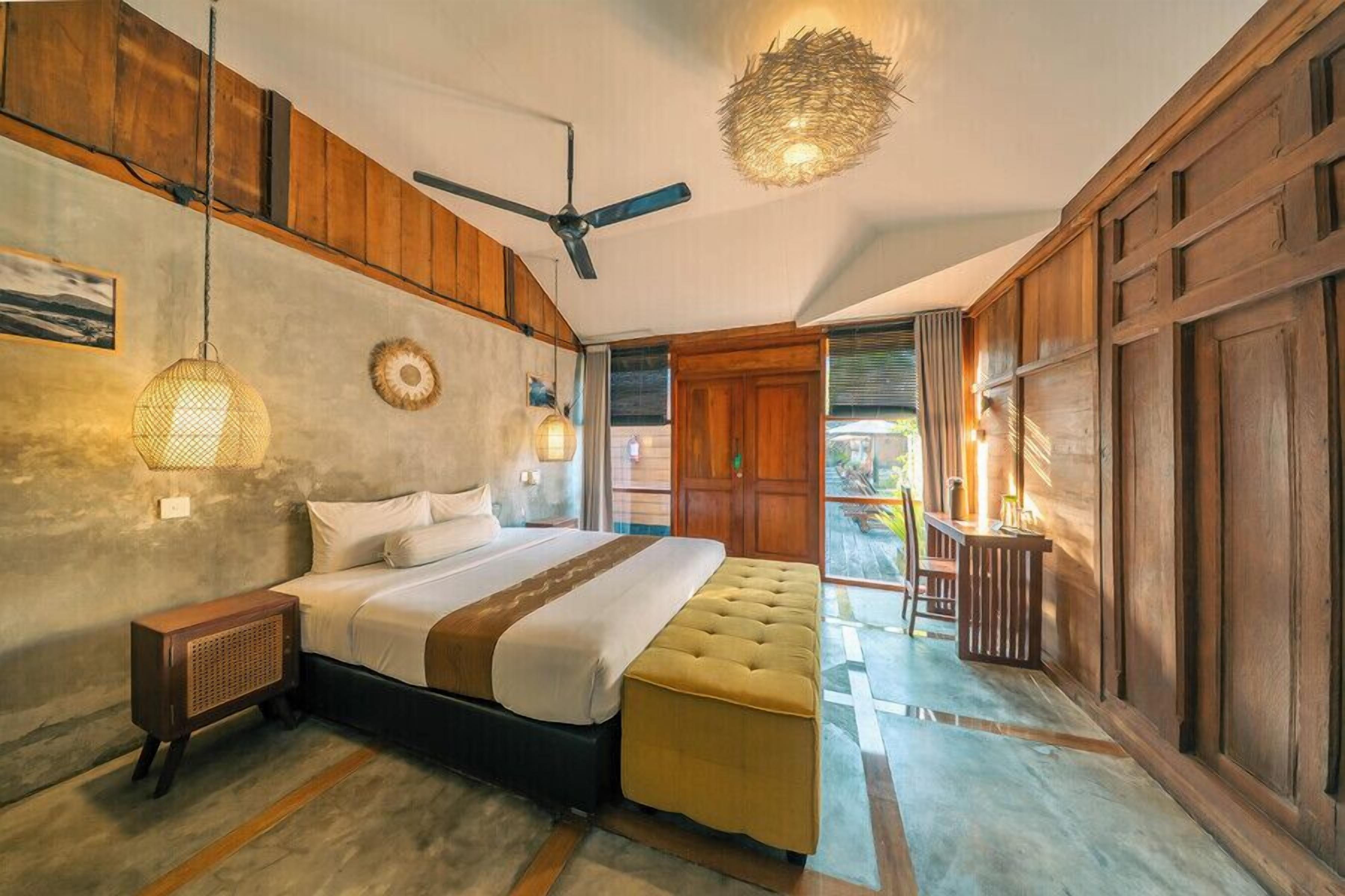 A bedroom with a bed, bedside table, and a ceiling fan.