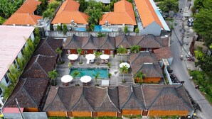 Een luchtendichtbeeld van een resort met meerdere gebouwen, een zwembad en buiten zitgedeeltes.