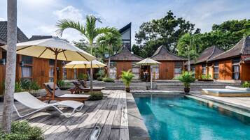 Una piscina al aire libre, sombrillas, tumbonas
