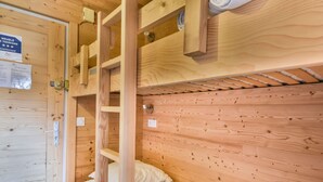 A wooden bunk bed with a ladder, a small shelf, and a wall-mounted light fixture. - Cozy 1BR + Alcove, Balcony, Near Slopes and Town, Sleeps 6 (Les Gets)