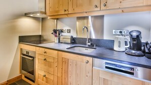 Een moderne keuken met houten kastjes, roestvrijstalen apparatuur en een inbouwoven.