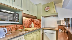 A compact kitchen with a built-in microwave, a coffee maker, and a dishwasher. - Duplex T3 in Les Gets - 5 pers, panoramic view, balcony, parking, WiFi (Les Gets)