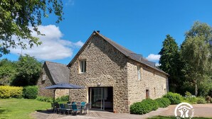 A stone building with a patio and outdoor seating area.