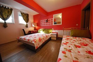 A bedroom with two beds, a window with curtains, a radiator, and a mirror on the wall. - Relax Home Rajna Korenica (Plitvicka Jezera)