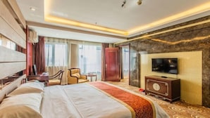 A hotel room with a large bed, a television, a desk, and a chair. - Taishengyuan Hotel (Shuozhou)